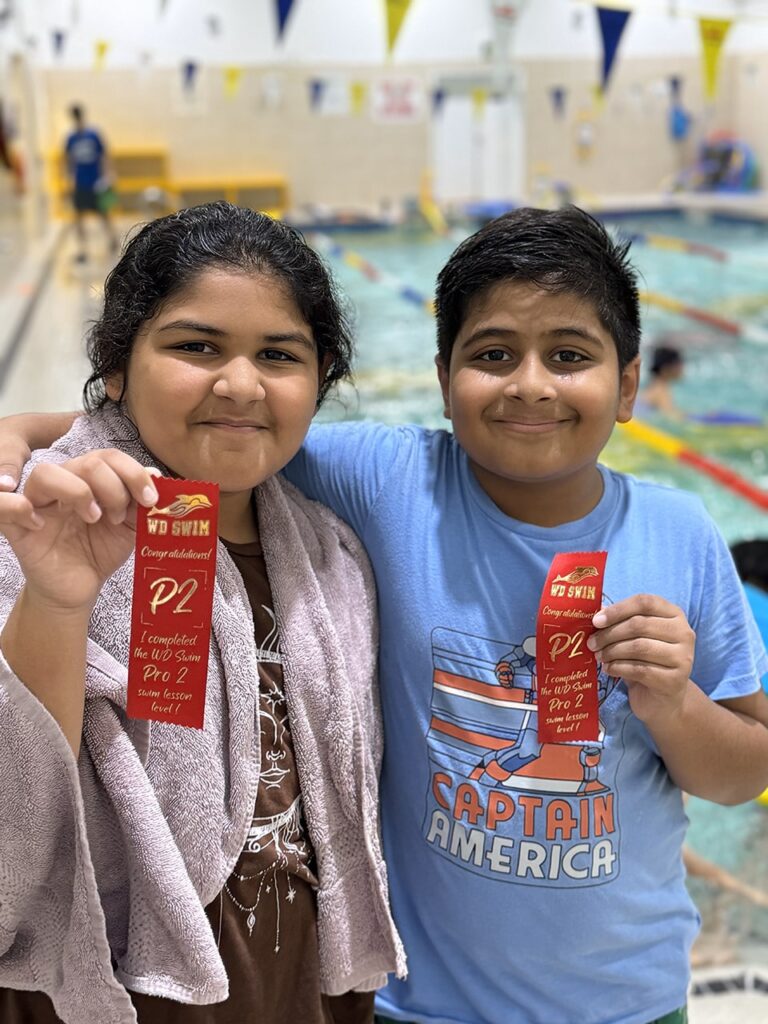 Two swimmers celebrating their ribbons at WD Swim Richmond Hill