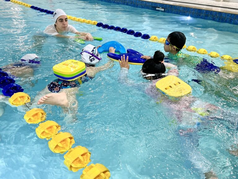 Kids learning to swim with kickboards at WD Swim Markham