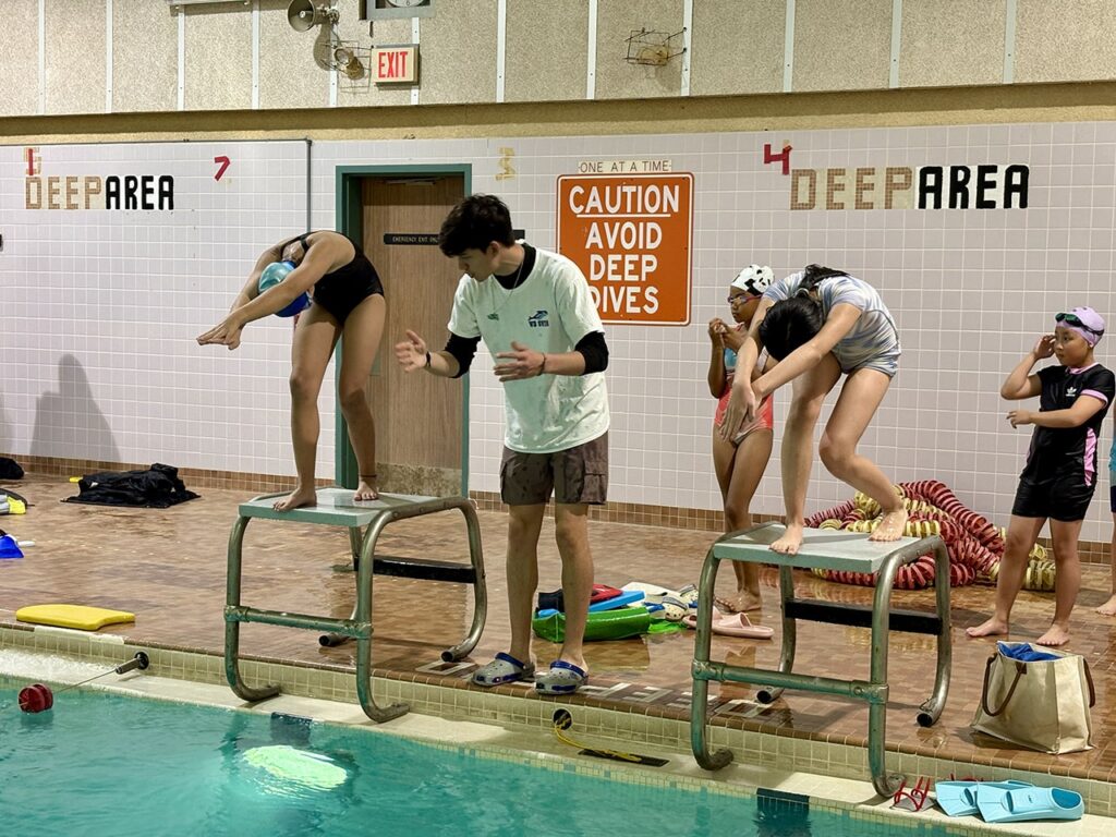 Swimmers practising racing starts at WD Swim North York