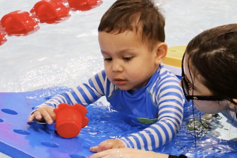 Toddler playing with a pool toy in a preschool lesson at WD Swim Markham