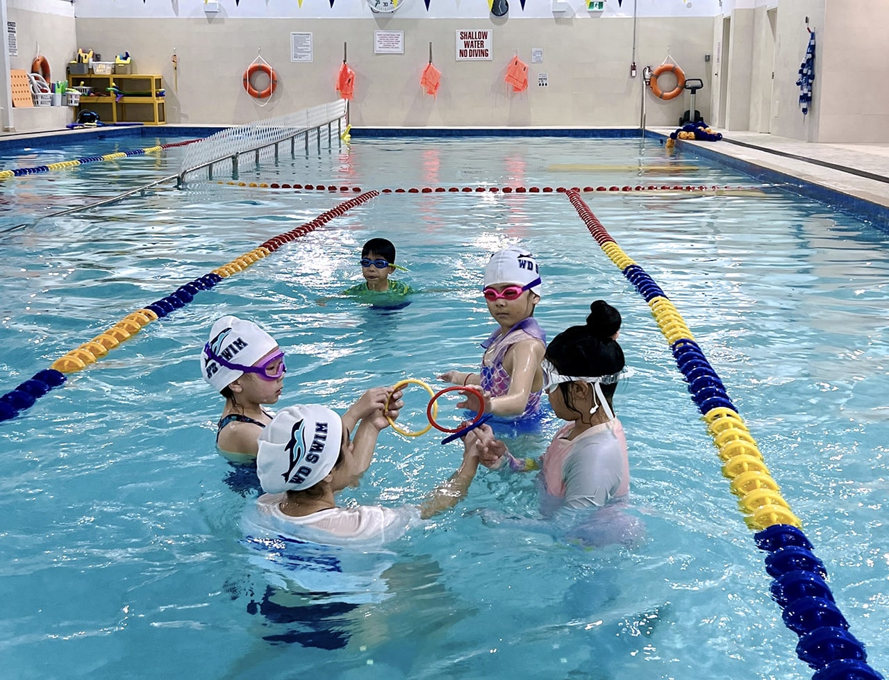 Kids in a swim camp lesson with coaches in the saltwater pool